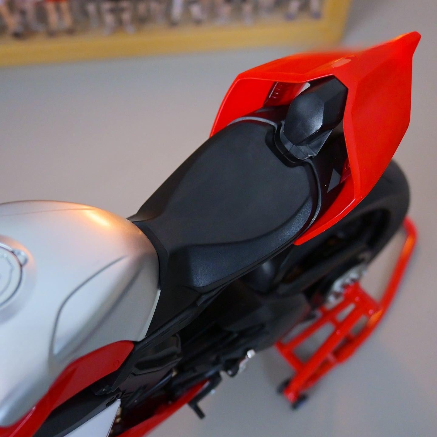Close-up of a motorcycle seat with red and black design on a blurred background