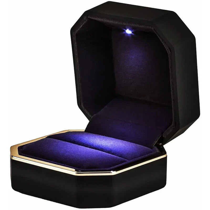 Engagement ring box with an automatic blue LED glowing over the ring inside a black octagonal piano finish case
