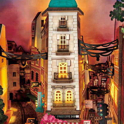 Model of a city street with buildings and street signs at night.