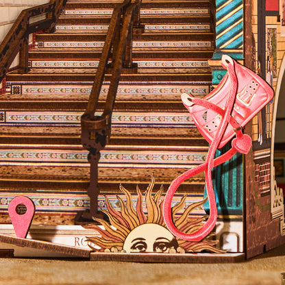 Decorative paper cutout with pink kite and sun design on a staircase background