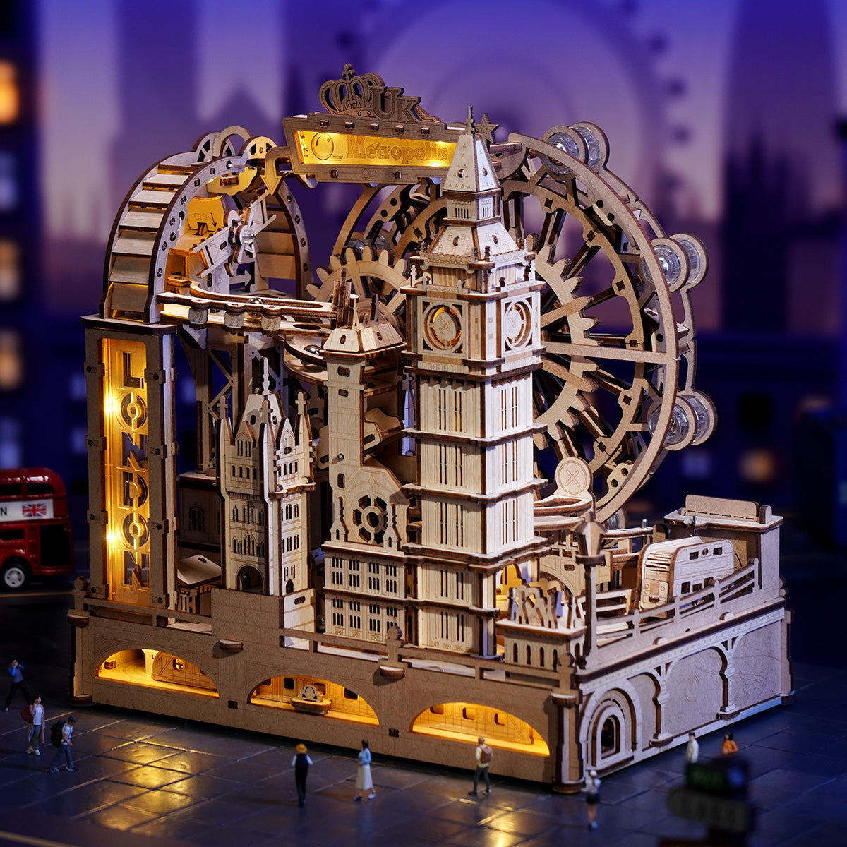 Wooden mechanical model of a clock tower with gears and lights on a blurred cityscape background