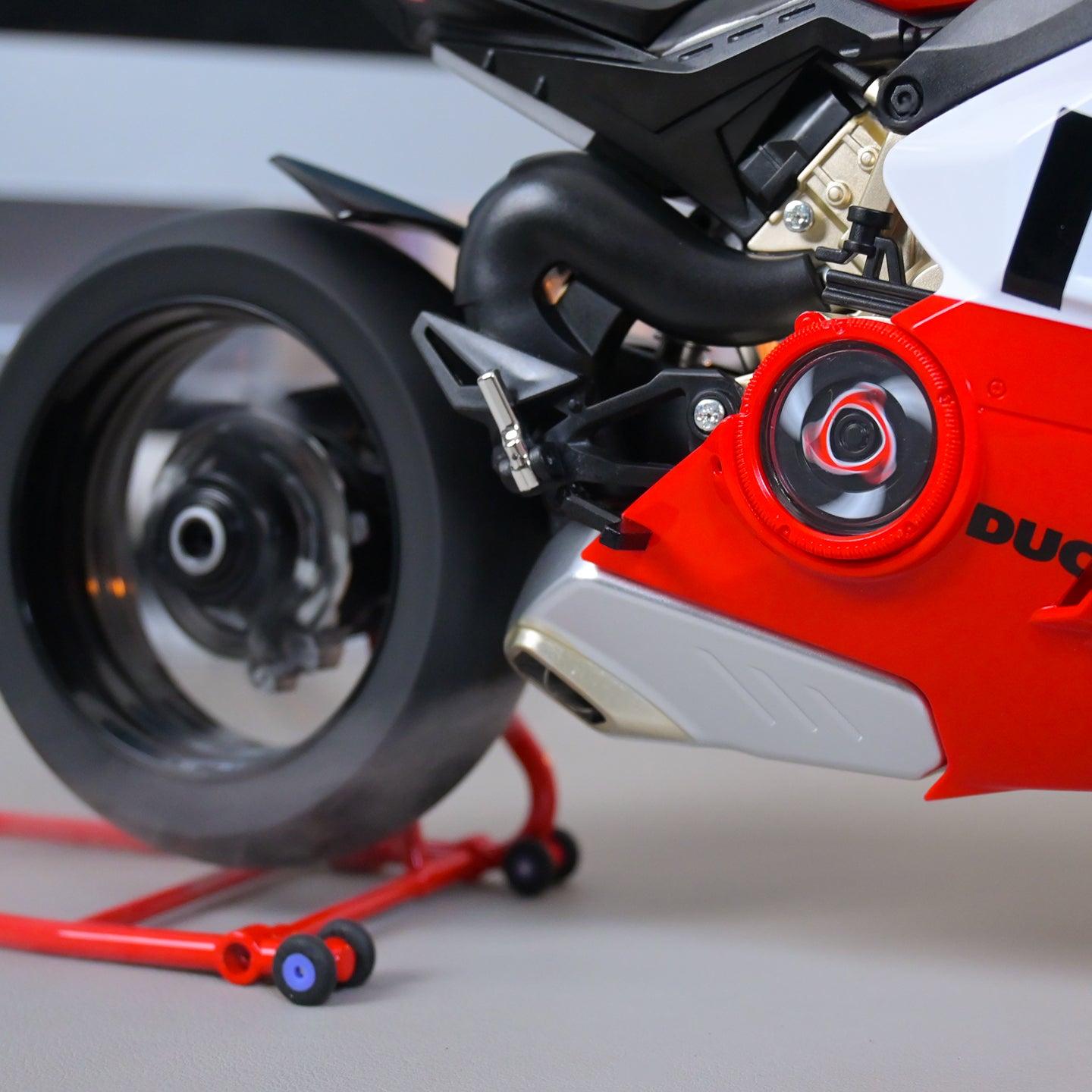 Close-up of a red and black motorcycle with 'Ducati' branding on a gray background