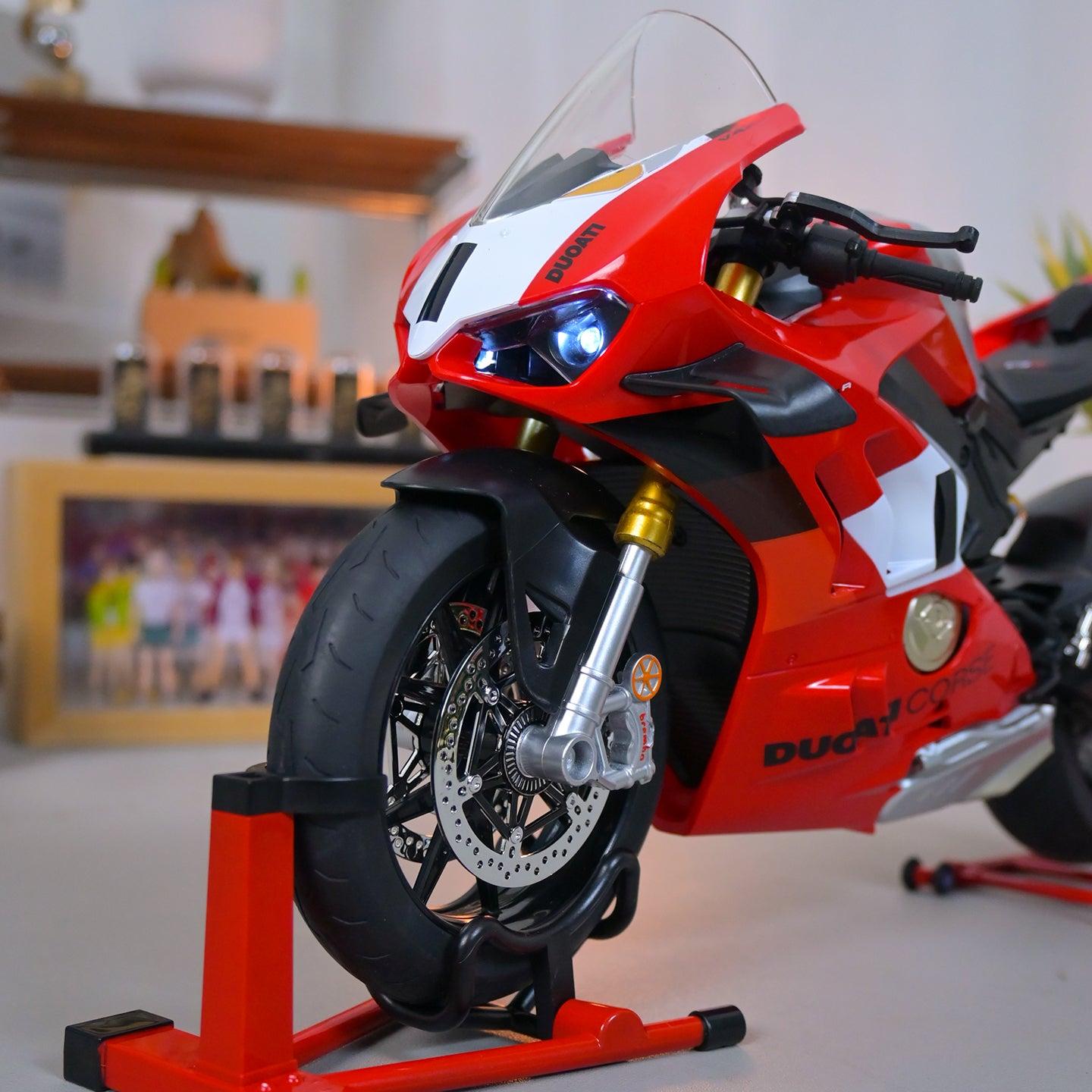 Red Ducati motorcycle model on a stand with a blurred indoor background