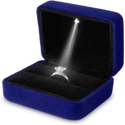 Diamond ring in a blue velvet box with a light shining on it LED ring box with automatic light for engagement proposals and wedding jewelry display