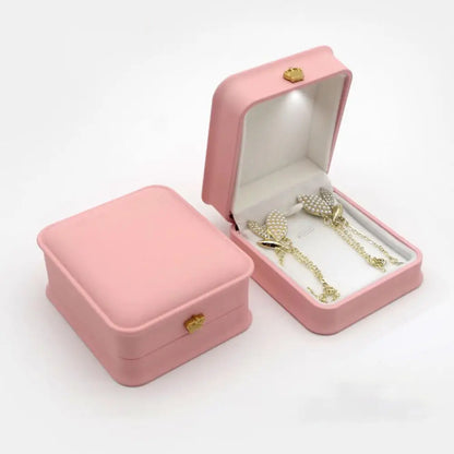 Pink jewelry box with gold jewelry inside LED ring box with automatic light for engagement proposals and wedding jewelry display