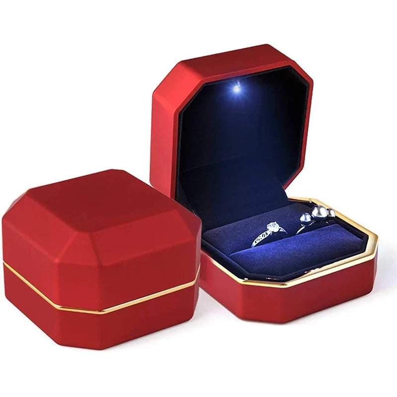 Red jewelry box with a blue interior containing a ring and earrings LED ring box with automatic light for engagement proposals and wedding jewelry display
