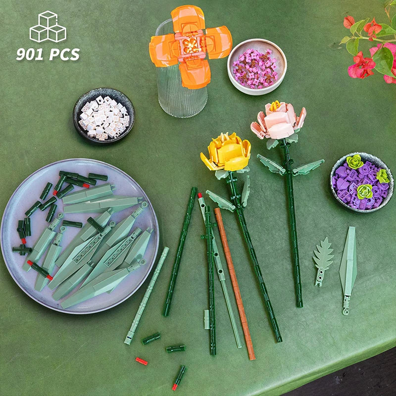 Children's building block set with flowers and accessories on a green surface, featuring the brand logo in the corner.