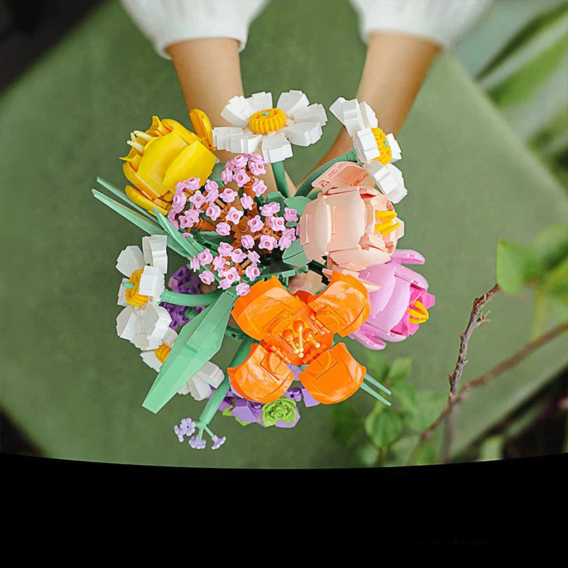Colorful flower arrangement held by a person with a green background