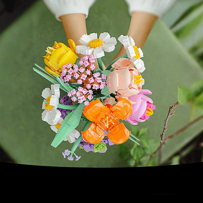 Colorful flower arrangement held by a person with a green background