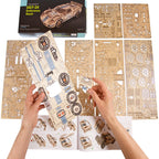 Hands working on a laser-cut wooden model kit with detailed parts and a box in the background.