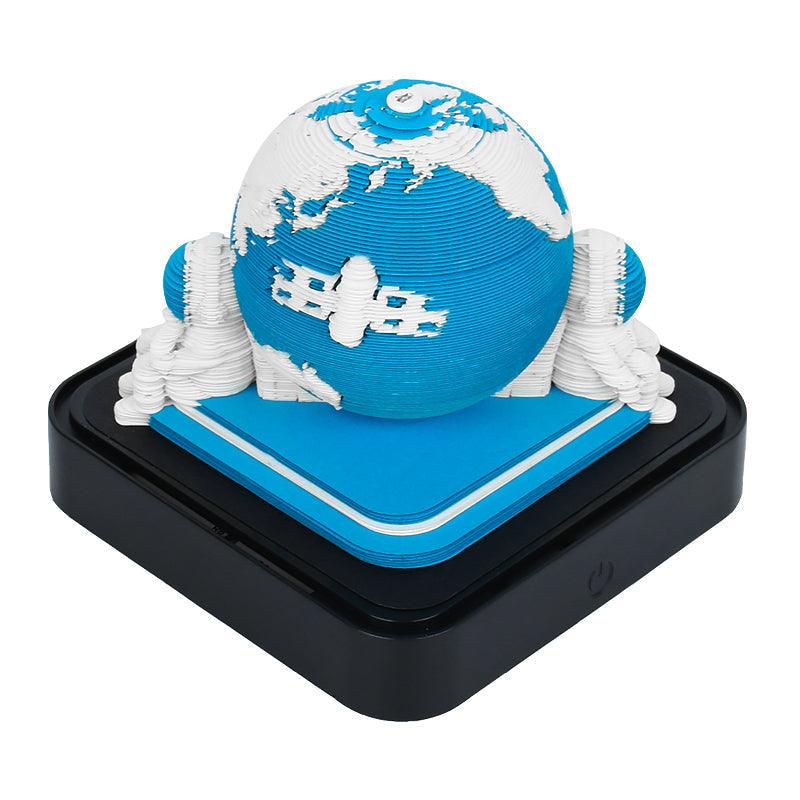 3D paper sculpture note pad shaping an Astronaut scene page by page, a glowing LED base and desk calendar for the office