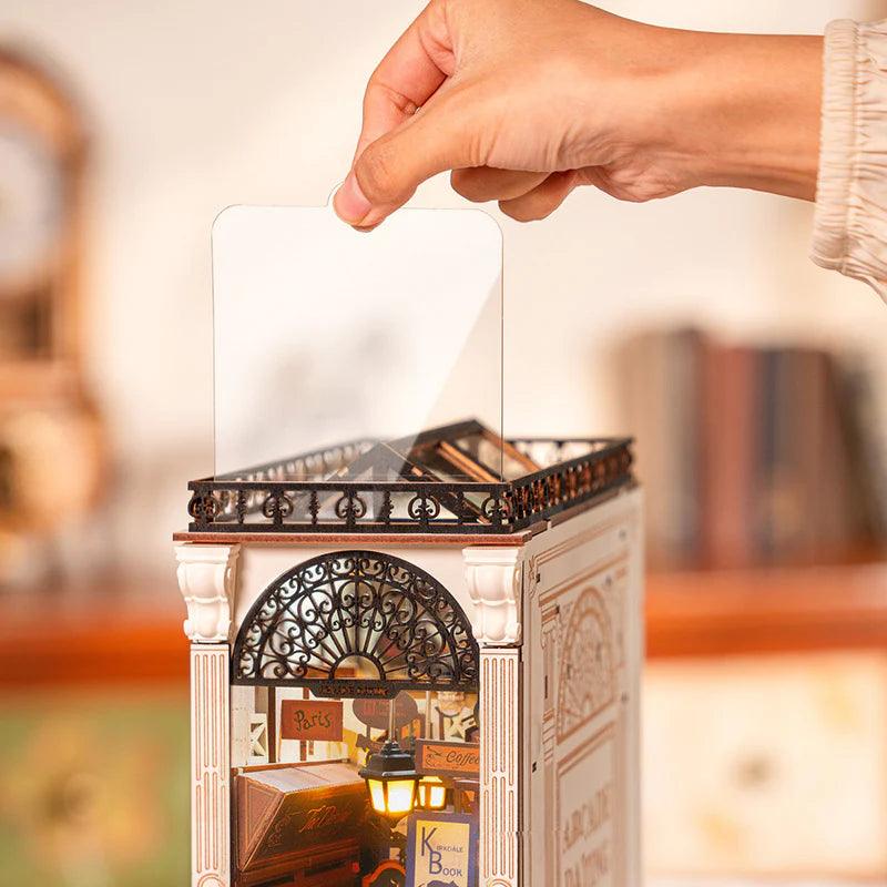 Clear dust proof panel sliding onto the finished book nook to keep the miniature cafe diorama clean on a shelf