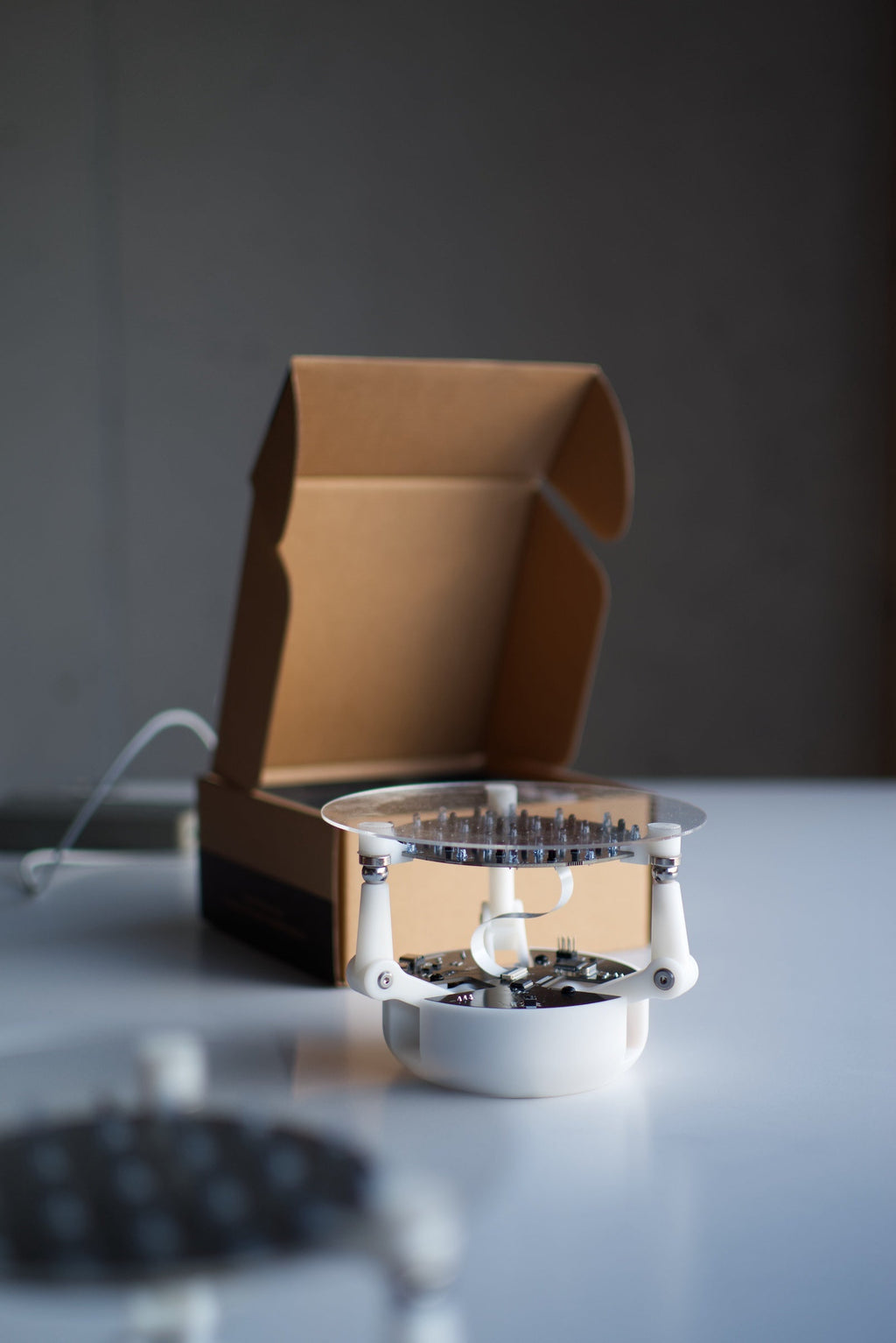 assembled ball balancing robot kit beside its box showing servo arms and control board, DIY STEM robotics build for makers
