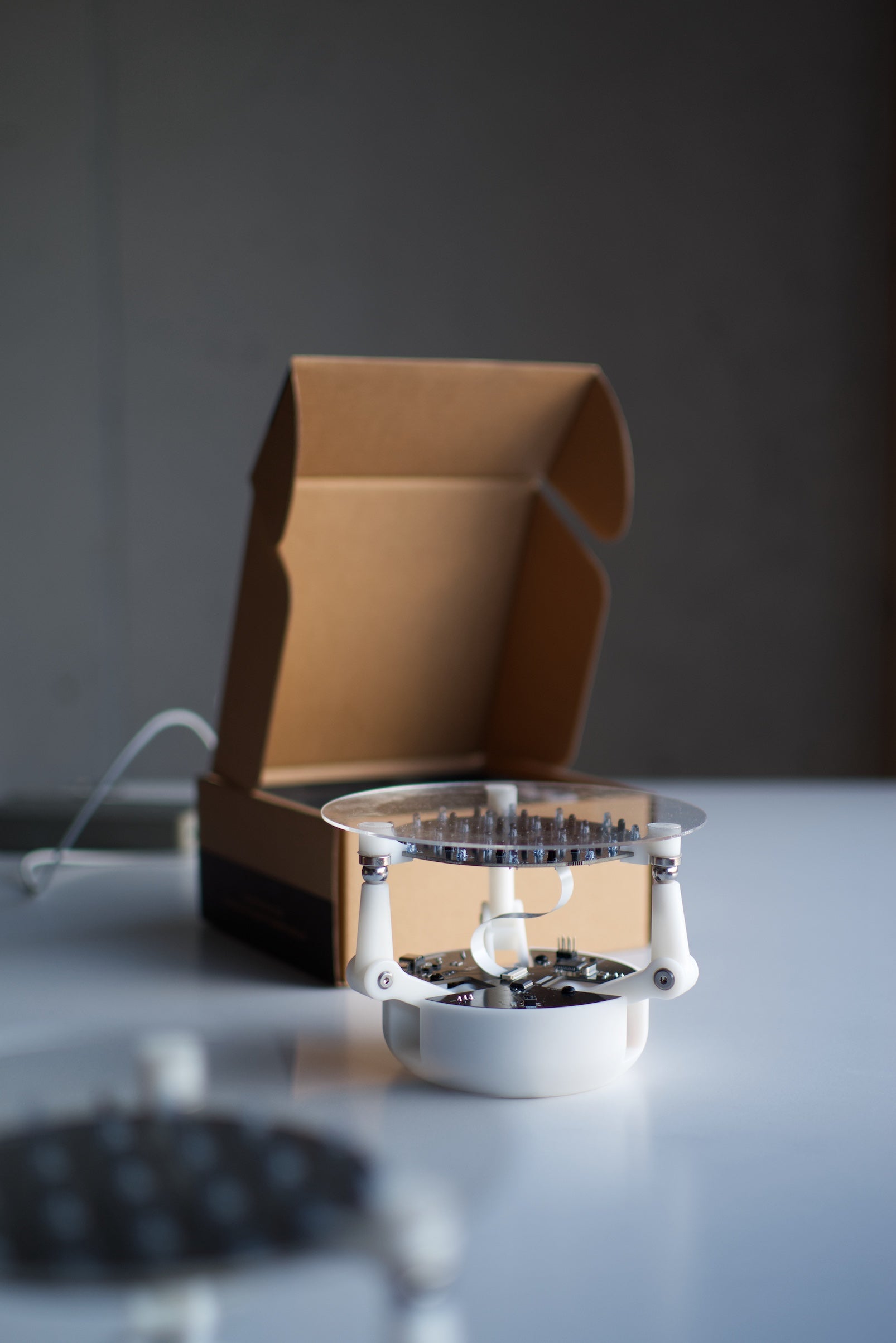 assembled ball balancing robot kit beside its box showing servo arms and control board, DIY STEM robotics build for makers