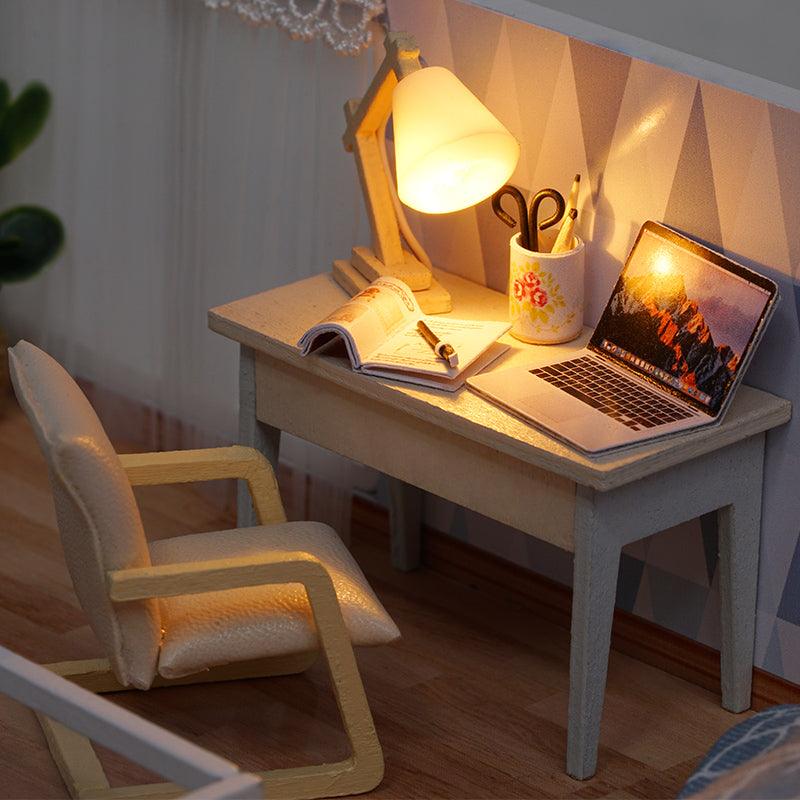 Tiny study desk nook with a lit lamp, laptop, and open book, a 1:24 miniature dollhouse kit for home decor fans