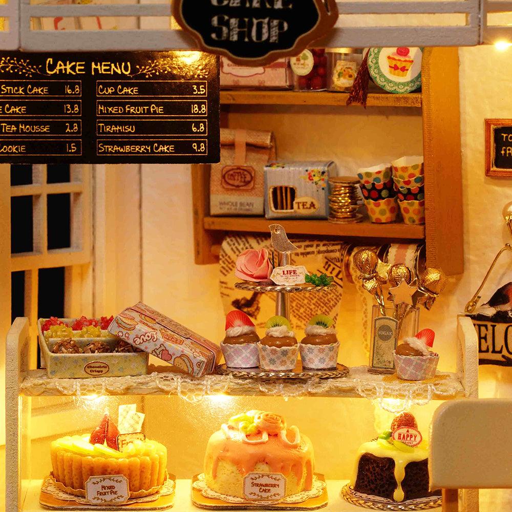 Miniature cake shop model with a printed dessert menu, tea tins, and cupcakes, a 1:24 bakery dollhouse kit for teens