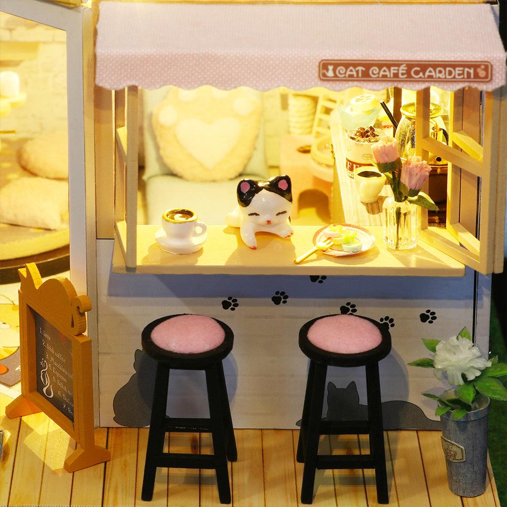 Handmade cat cafe counter with a napping kitten in sunglasses, bar stools and a chalkboard menu for a whimsical shelf display