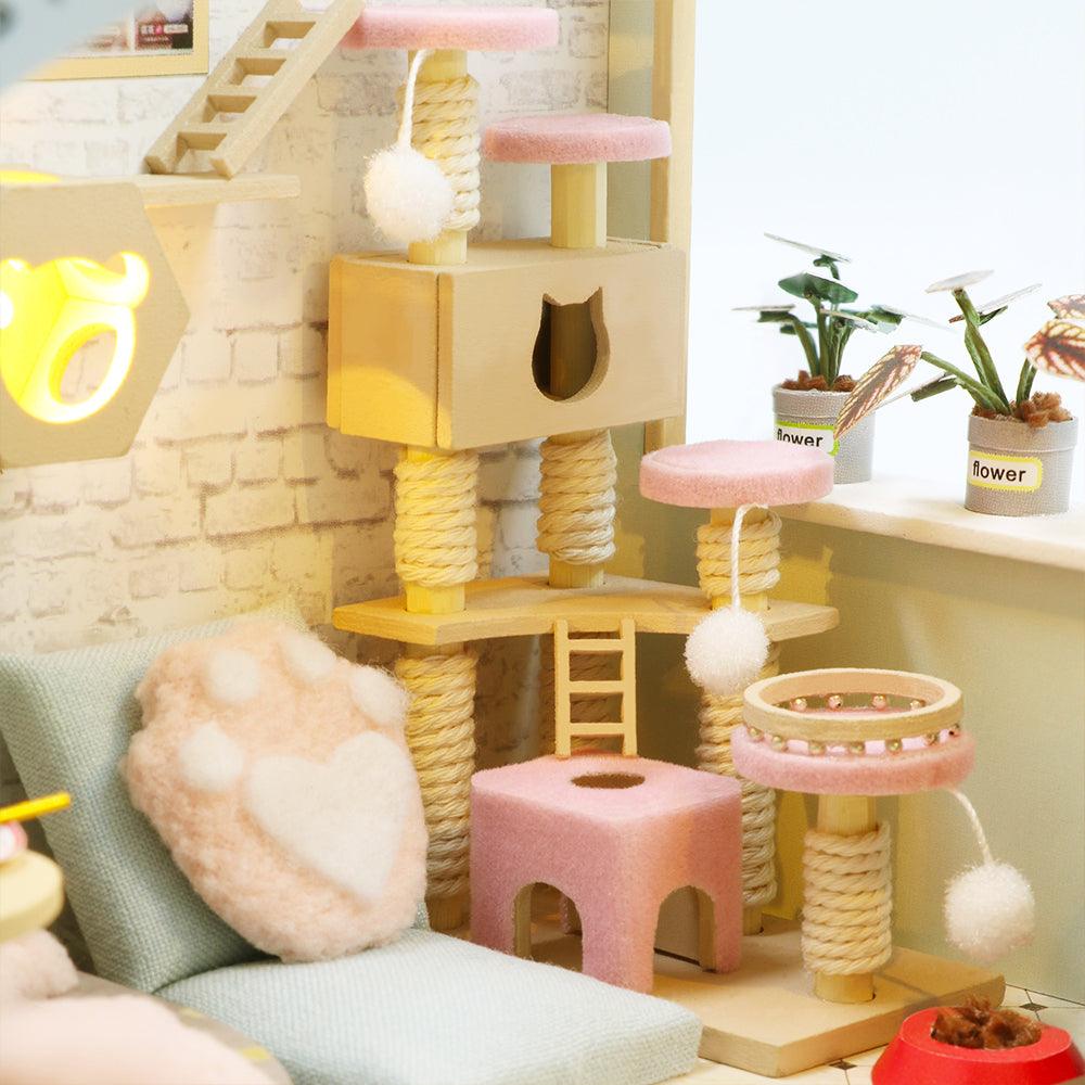 Miniature wooden cat tree with sisal posts, pom pom toys and a snug cat condo, a detailed dollhouse feature for kitten lovers