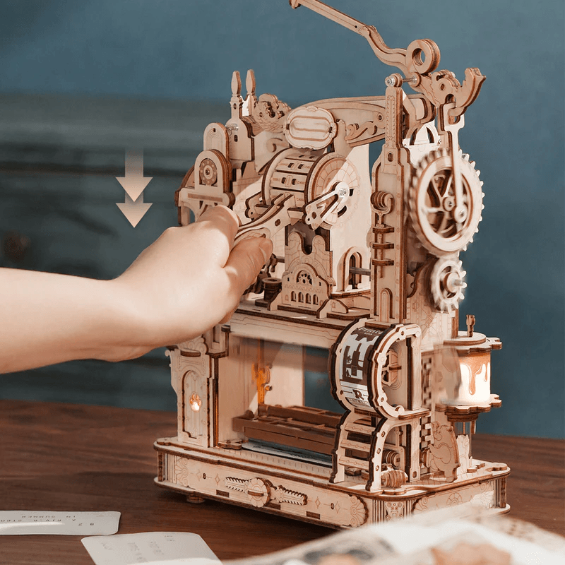 Hand-cranked wooden letterpress printing custom cards on a desk, mechanical moveable-type model kit for teen and adult crafters