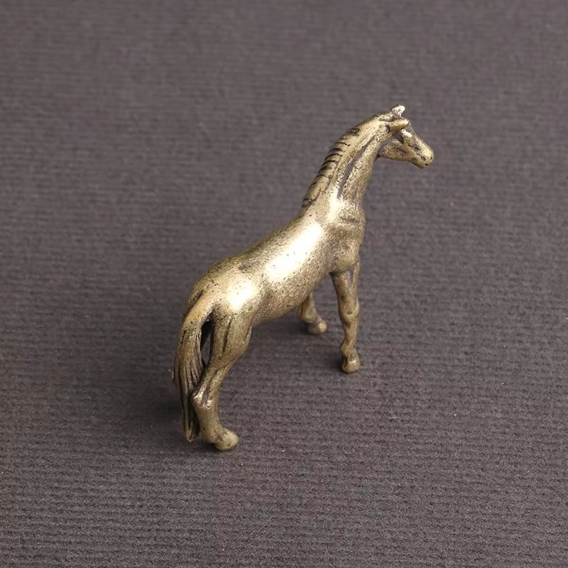 Miniature brass horse statue showing a sculpted tail and flowing mane, a vintage zodiac desk ornament for shelves and offices