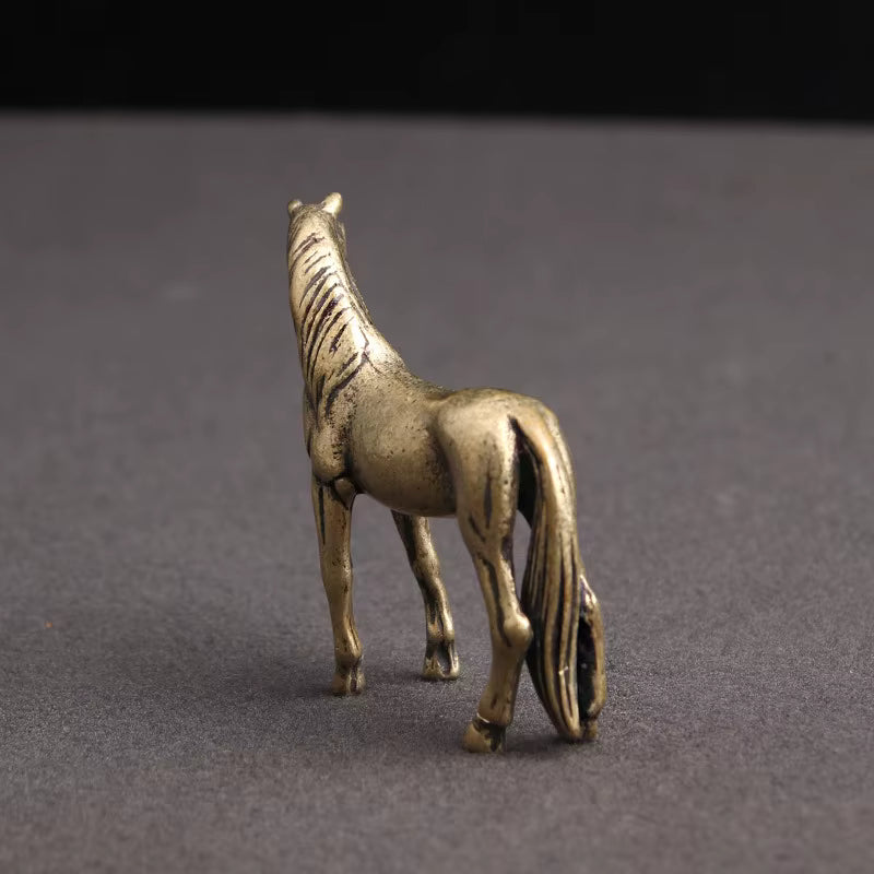 Vintage brass horse statue viewed from behind with a braided tail, a small copper zodiac ornament for desk and mantel decor