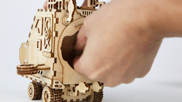 Cosmic Voyager spaceship music box turning as it plays a melody, a kinetic steampunk wooden model for teens and adults
