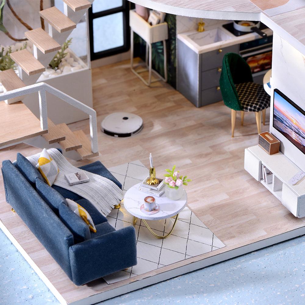 Miniature living room with a navy velvet sofa, TV unit, and robot vacuum, a 1:24 modern loft dollhouse kit for adults