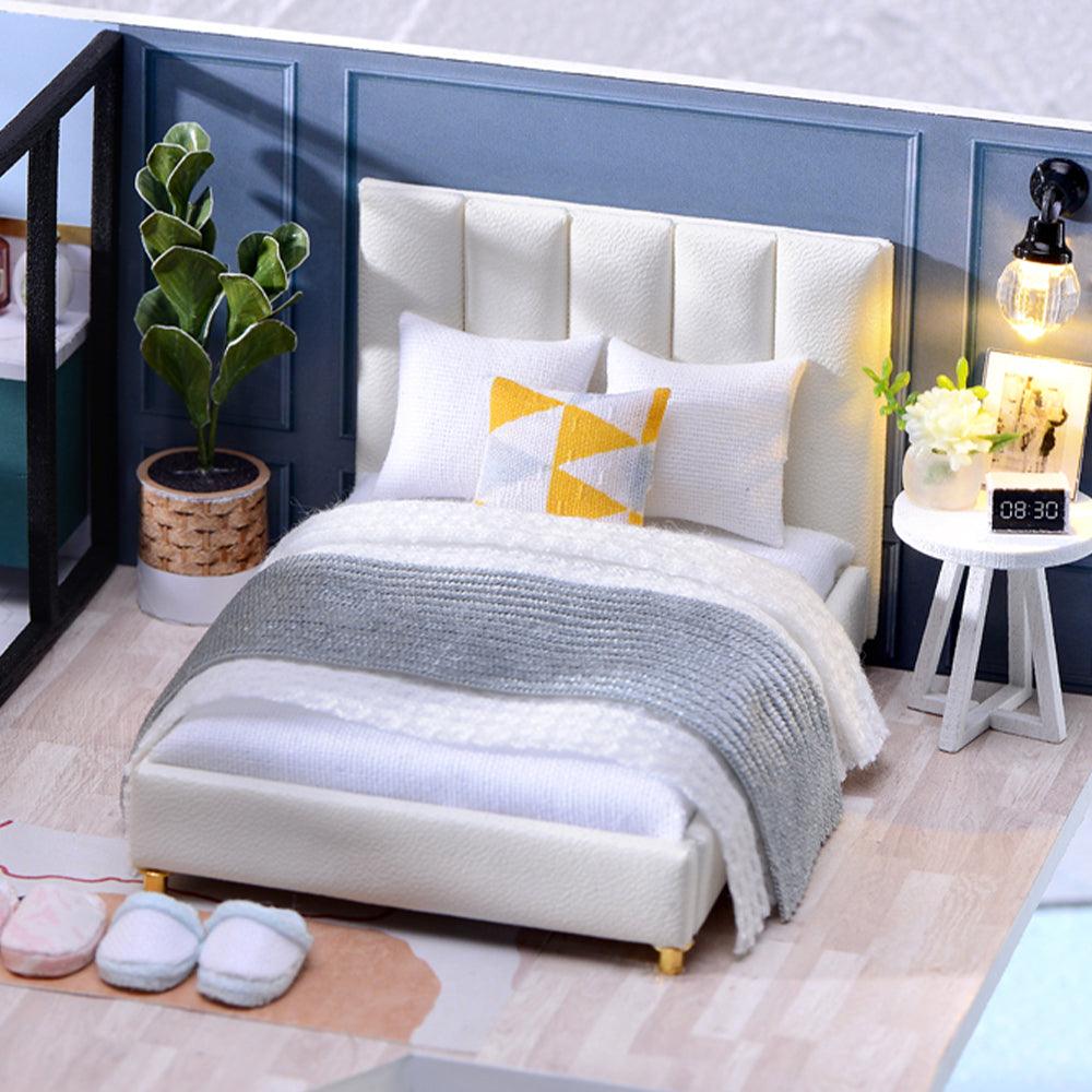 Miniature master bedroom with a tufted headboard and knit throw, a 1:24 modern loft dollhouse kit for home decor fans