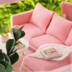 Pink miniature sofa and coffee table in a 1:24 scale dollhouse living room, a DIY apartment kit and craft gift for adult builders