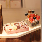 Miniature sweet shop counter with tiny lollipops and chocolates, a hands on laser cut craft kit for miniature lovers