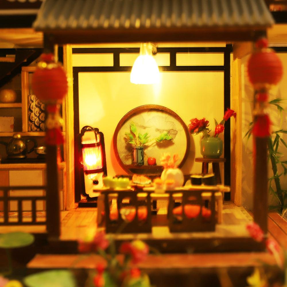 Miniature Japanese house interior with red lanterns and a lit dining room, a hands on craft kit for adult hobbyists