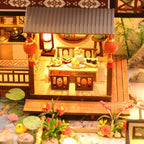 Miniature dollhouse patio with an outdoor dining set beside a lily pond, a detailed diorama gift for dollhouse fans