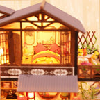 Miniature house upstairs bedroom with warm LED lighting and sliding lattice doors for a cozy desk or bookshelf display