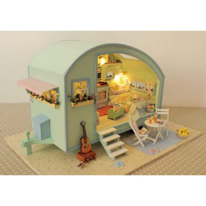 Mint green miniature camper model with an open furnished interior, a 1:24 scale caravan build for hobby shelf display