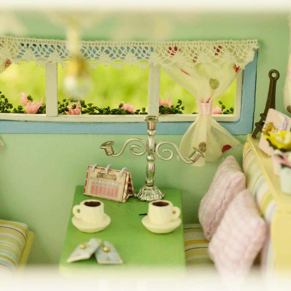 Tiny caravan seating nook with a table and coffee cups by the window, a furnished camper scene for miniature collectors