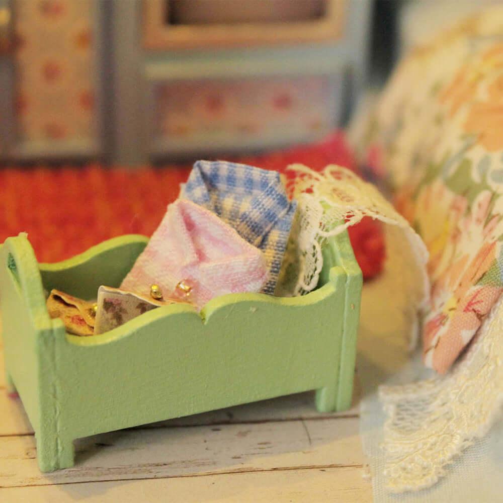 Little green bed with patterned bedding in a miniature caravan, a retro camper furnishing for a 1:24 model kit build