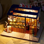 LED lit miniature sushi bar dollhouse glowing on a desk as handmade shelf decor and a relaxing adult craft hobby build Cute sushi