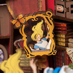 Lit miniature book nook that slots between books as a glowing reading nook accent and whimsical desk display piece