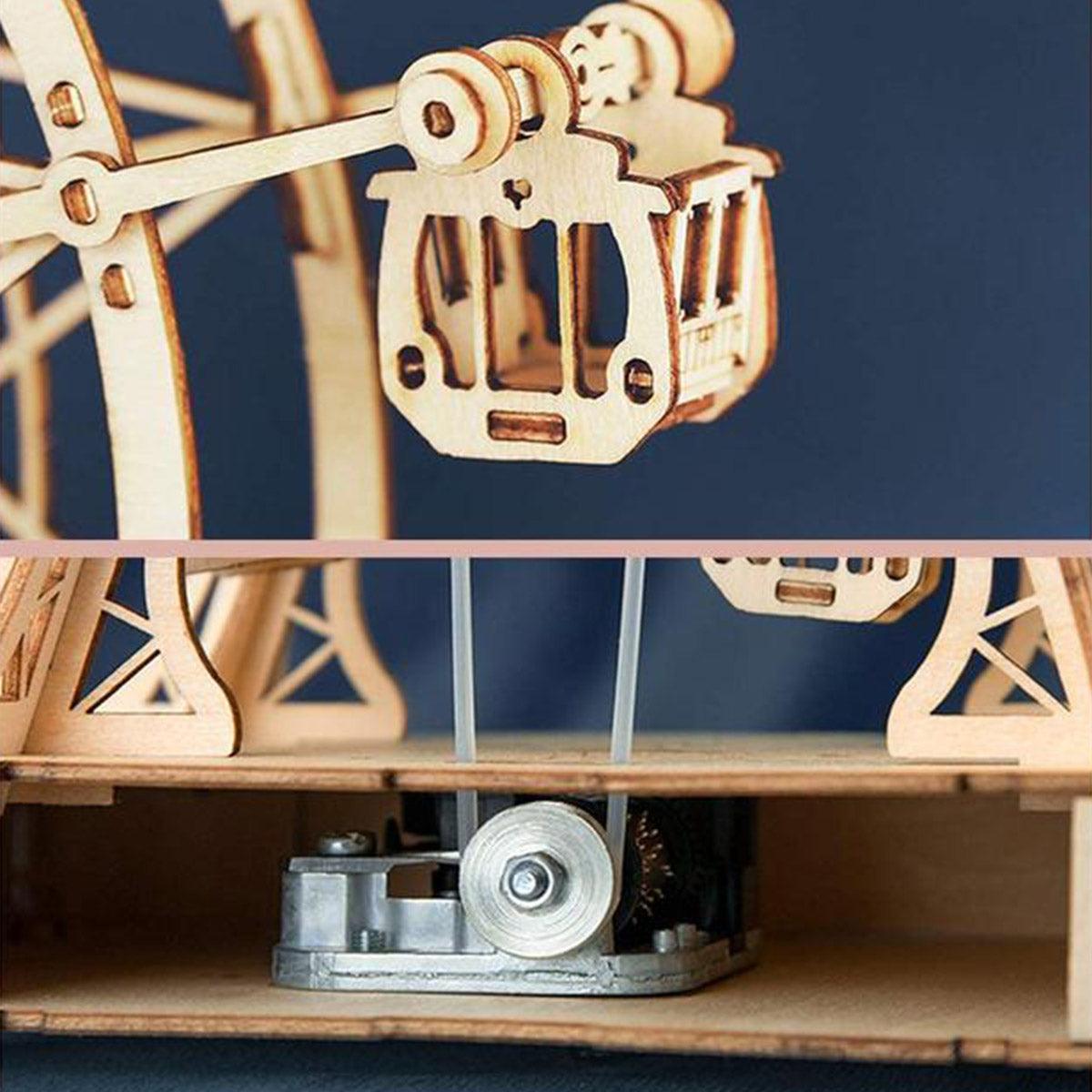 Wind up music box mechanism beneath a wooden ferris wheel that spins and plays a tune, a mechanical build for adults