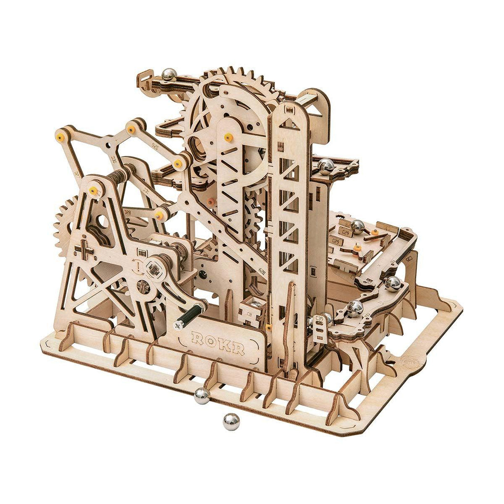 Wooden marble run kit built from 227 pieces with gears and spiral tracks that guide steel marbles through a fortress