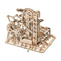Wooden marble run kit built from 227 pieces with gears and spiral tracks that guide steel marbles through a fortress