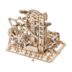 Wooden marble run kit built from 227 pieces with gears and spiral tracks that guide steel marbles through a fortress
