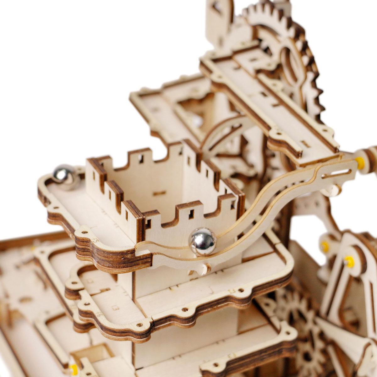 Steel marbles roll down curved slopes and lifts powered by cranks and gears in this hands on mechanical marble track