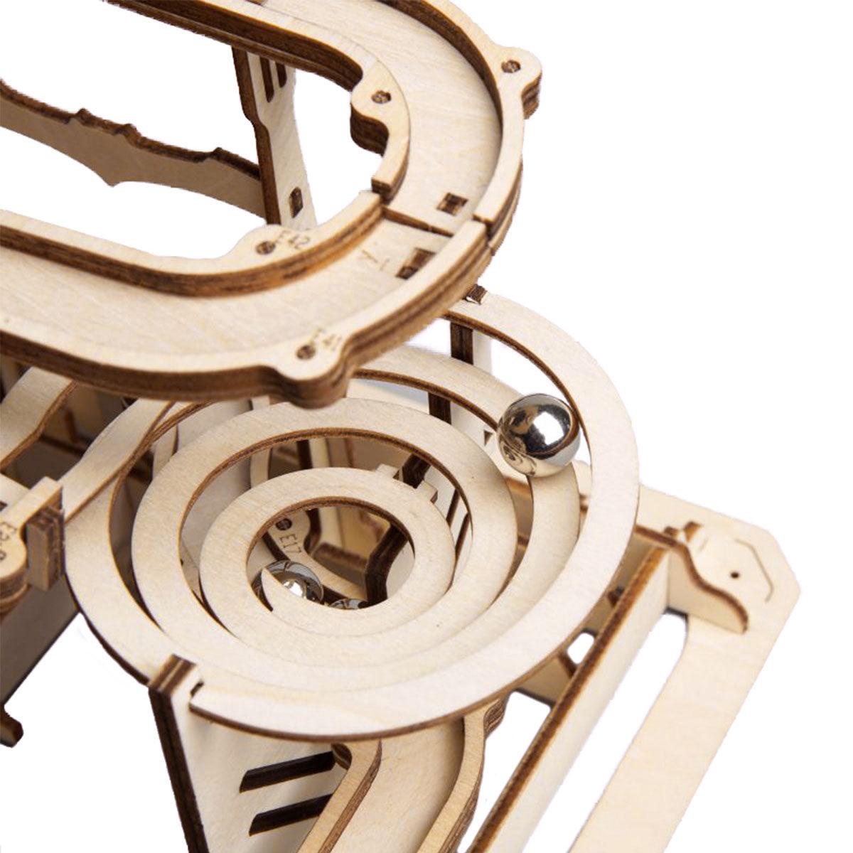 Spiral funnel rail guiding a steel marble down the track, a mechanical wooden puzzle build with gears for hands-on STEM play