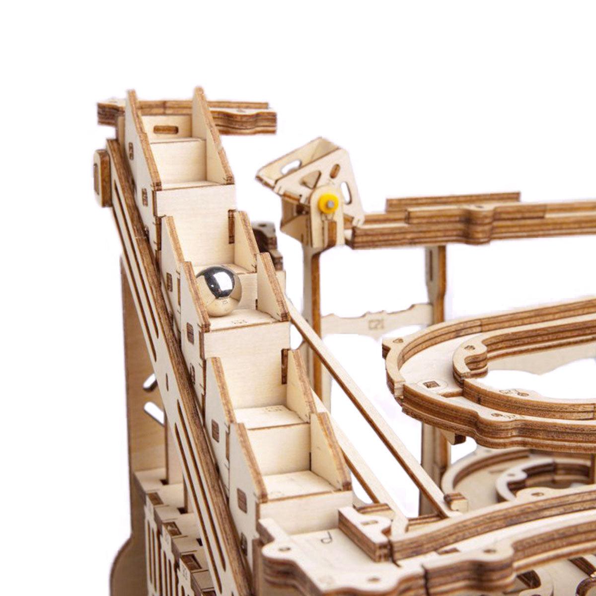 Stair step lifter carrying marbles up to switchback ramps, an engaging gear driven marble track kit for teens and adults