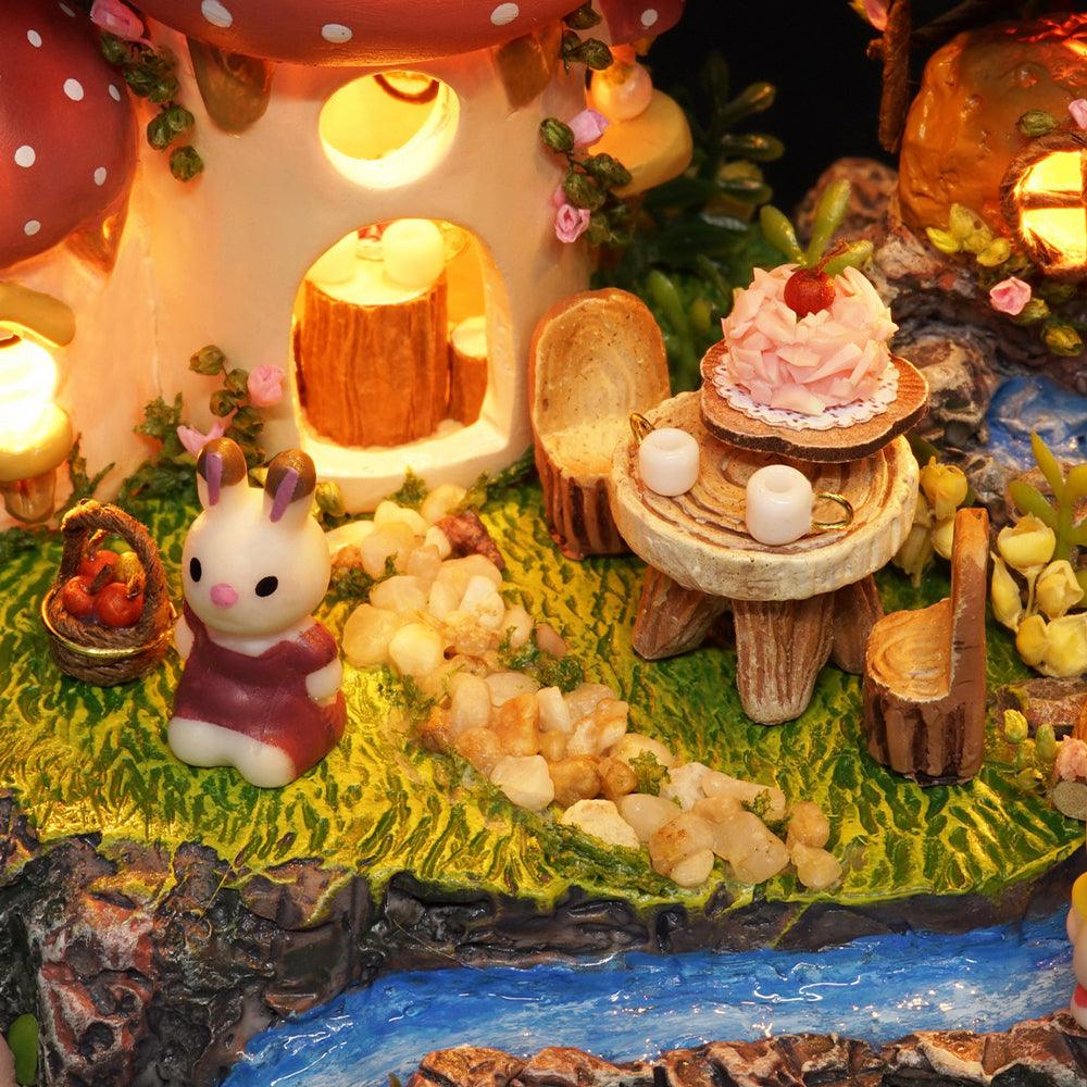Toadstool mushroom cottage with glowing windows and a tiny tea table, a whimsical fairy garden miniature build for hobbyists