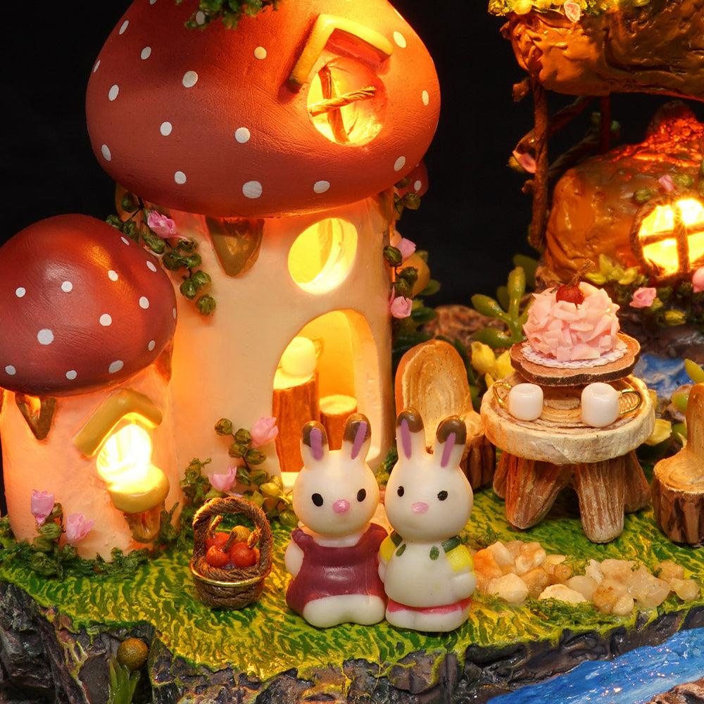 Warm LED mushroom houses lighting a nighttime woodland scene with bunny figures, a cozy miniature dollhouse craft kit for adults