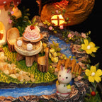 Fairy garden tea party table beside a flowing stream and glowing cottage window, a woodland miniature kit gift for crafters