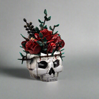 Dark botanical skull bouquet with eucalyptus leaves and blackberry sprigs, a LEGO-compatible brick centerpiece for decor