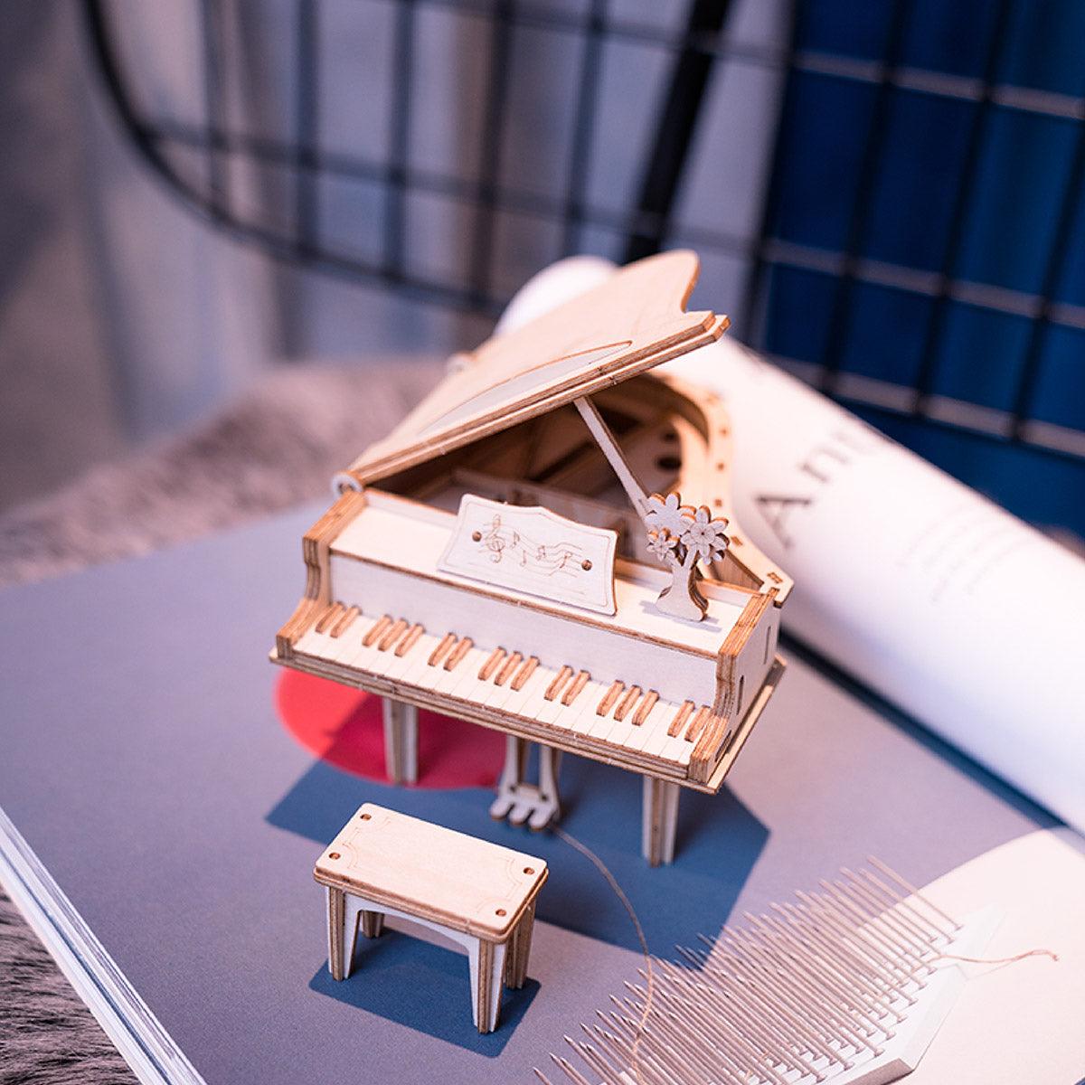 Miniature concert grand piano model with detailed keyboard and raised lid, a screen-free wooden building project for adults